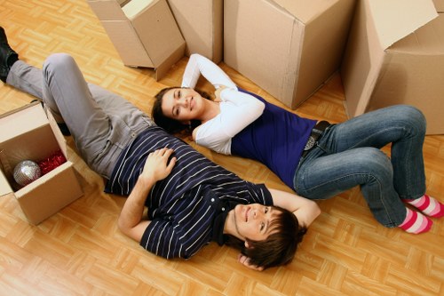 Removal crew carrying business furniture through a narrow Stepney access point